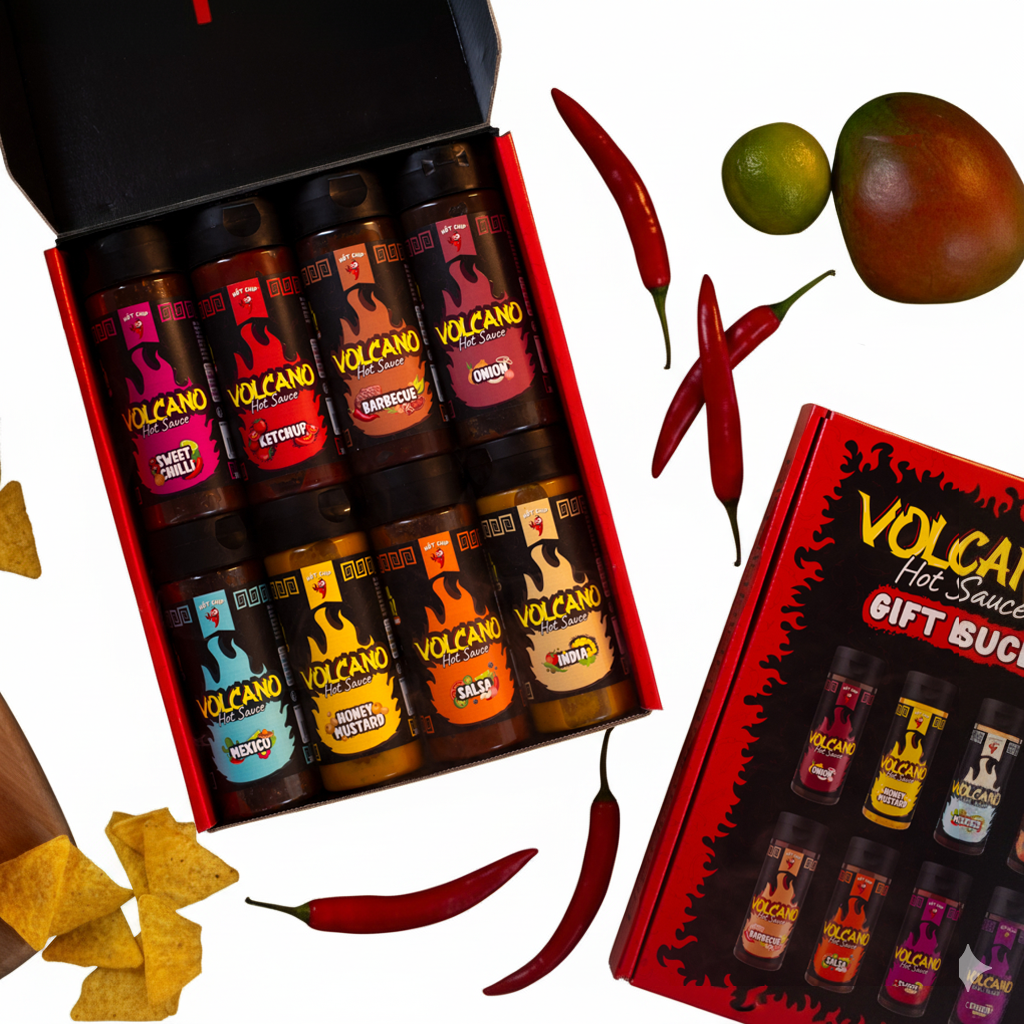 Geschenkbox mit 8 Flaschen Volcano Hot Sauce, umgeben von Chilischoten, Limette, Tamarillo und Nachos