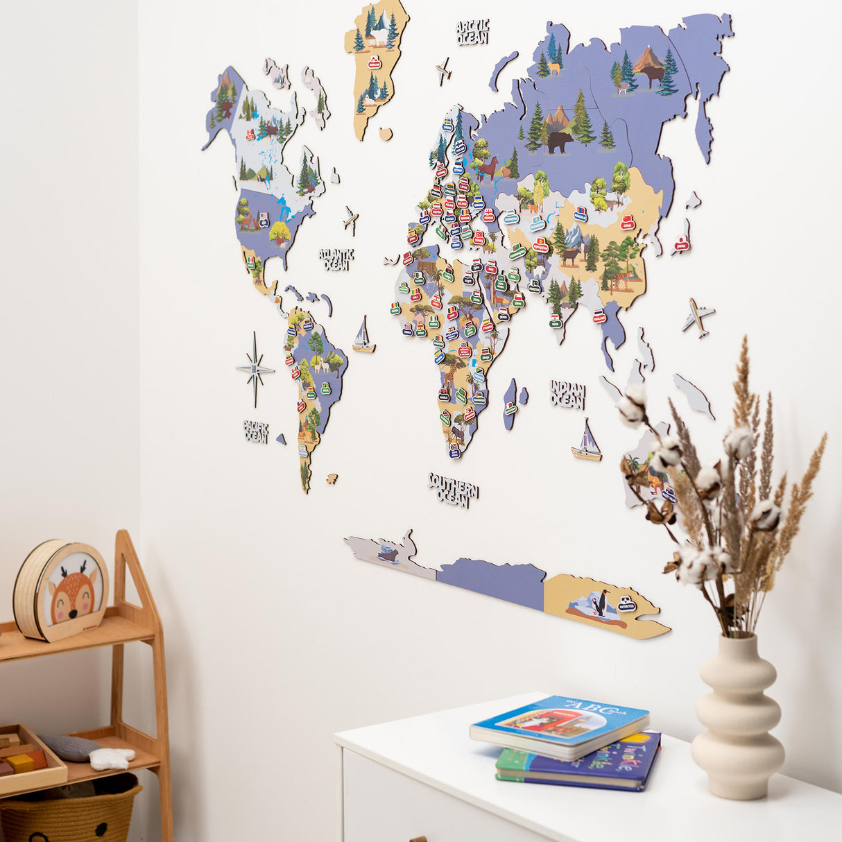 Dekorative Weltkarte aus Holz mit Tierillustrationen an einer weißen Wand
