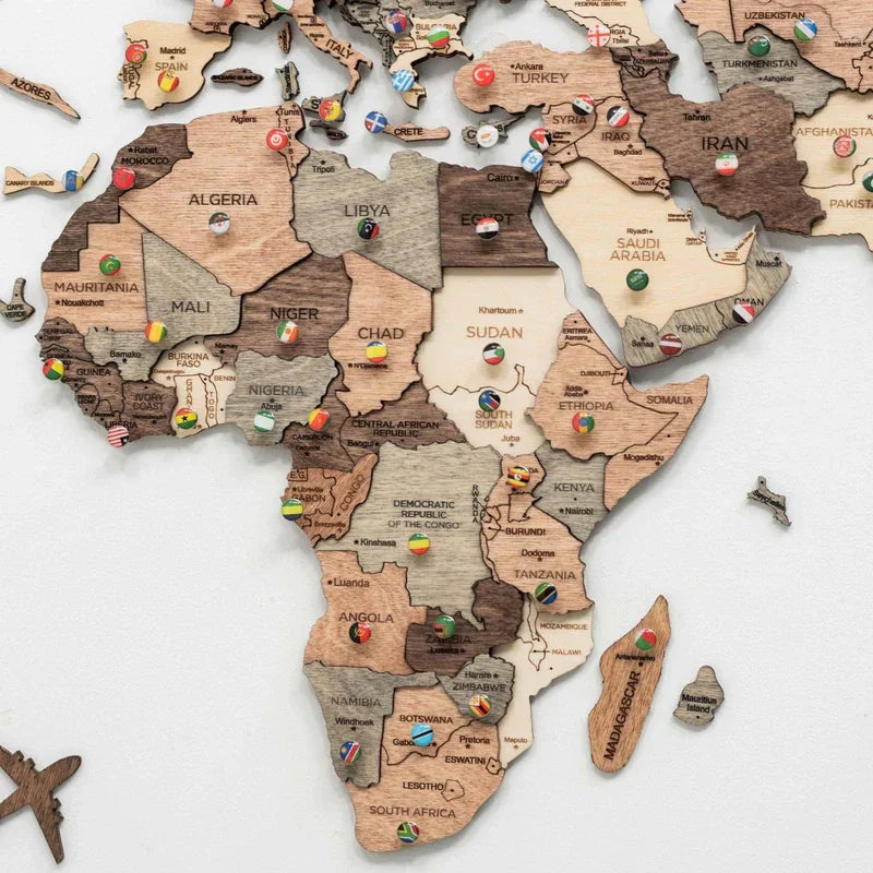 Holzweltkarte mit Stecknadeln, die Flaggen in verschiedenen Ländern Afrikas, Europas und Asiens zeigen