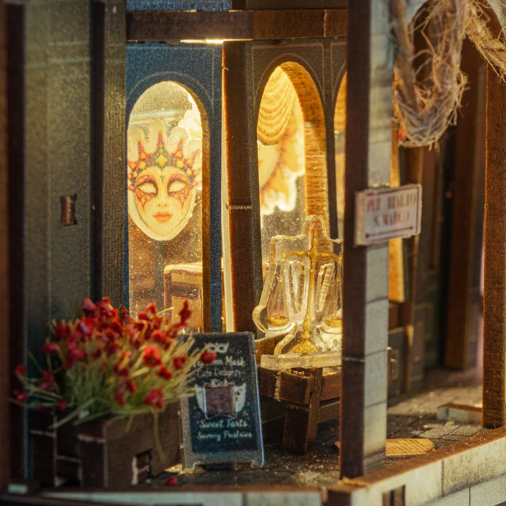 Schaufenster-Detail mit venezianischer Maske, Schildern und warmem LED-Licht