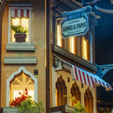 Detailansicht der Hotelfassade Albergo Lungo Il Fiume mit beleuchteten Fenstern im Book Nook