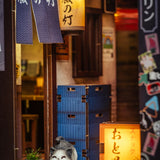 Miniaturmodell einer japanischen Gasse mit Lampions und einer Katzenfigur