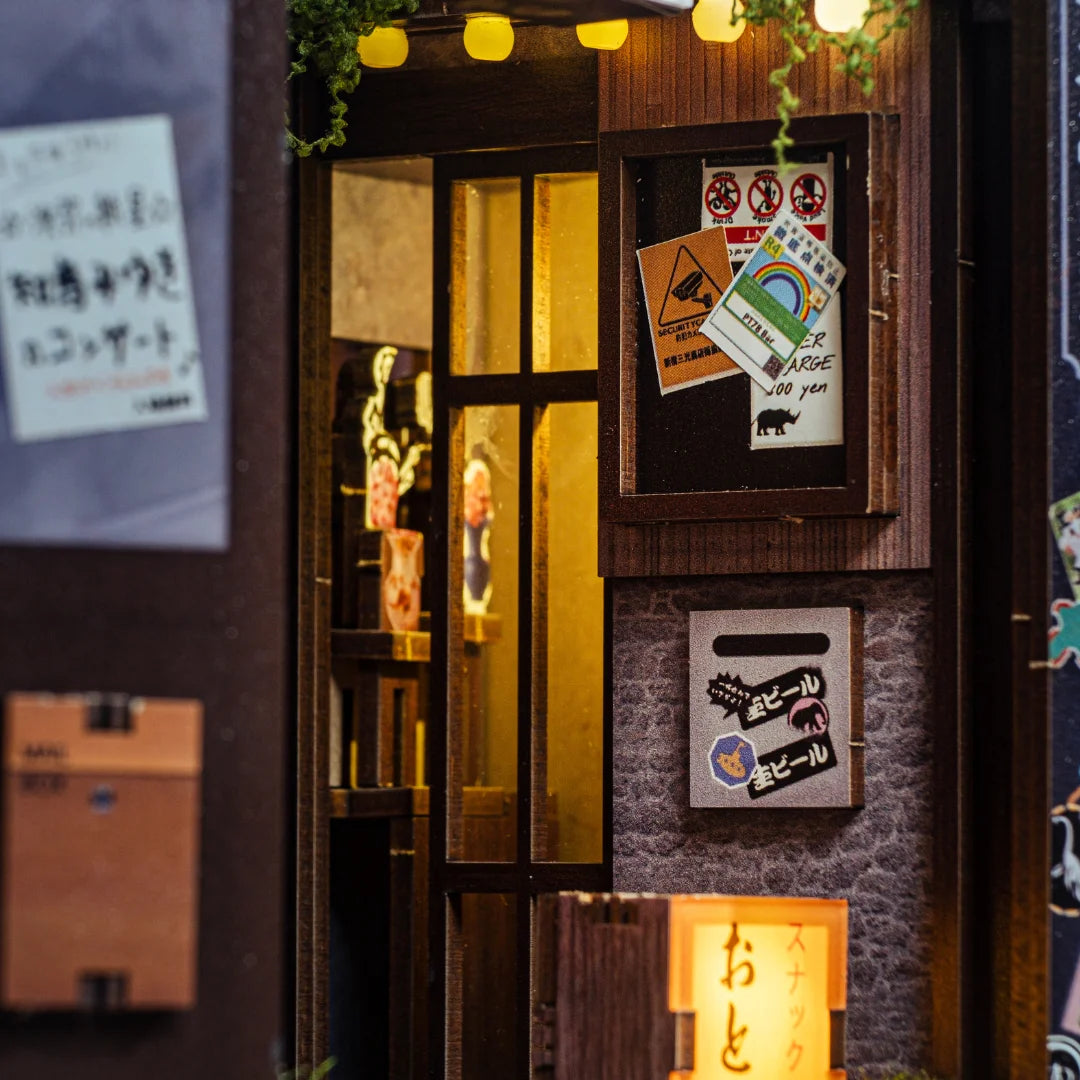 Miniaturmodell eines japanischen Ladeneingangs mit beleuchtetem Fenster und Schildern an der Wand