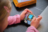 Kind hält den fertig gebauten CircuitMess Codee mit laufendem Mini-Spiel in den Händen