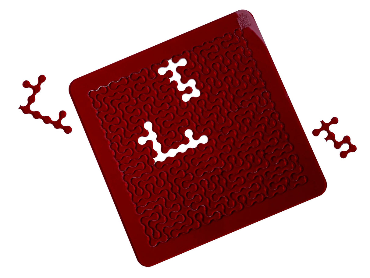 Das rote Acryl-Rätsel aus dem Puzzle Colors Trio von ESC WELT mit geschwungenen, organischen Formen und herausgenommenen Teilen.