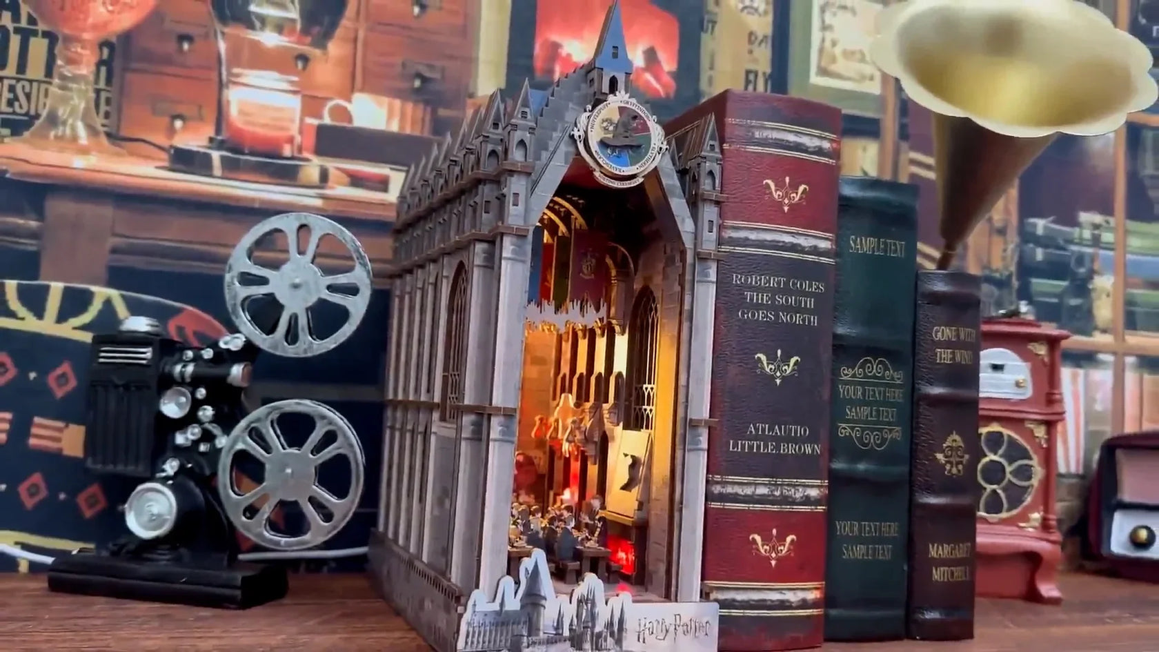Beleuchtetes Harry Potter Buchnook Modell zwischen dekorativen Buchattrappen und einem Filmprojektor