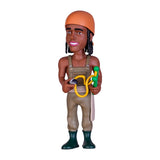 Spielfigur eines Mannes mit orangefarbener Mütze und Latzhose hält eine gelbe Schleuder