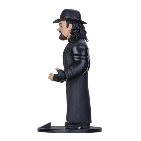 Sammelfigur von The Undertaker in schwarzem Mantel und Hut von der Seite